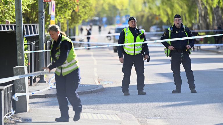 Police officers near the scene after the deadly shooting in Uppsala, Sweden. Pic: TT News Agency/Reuters