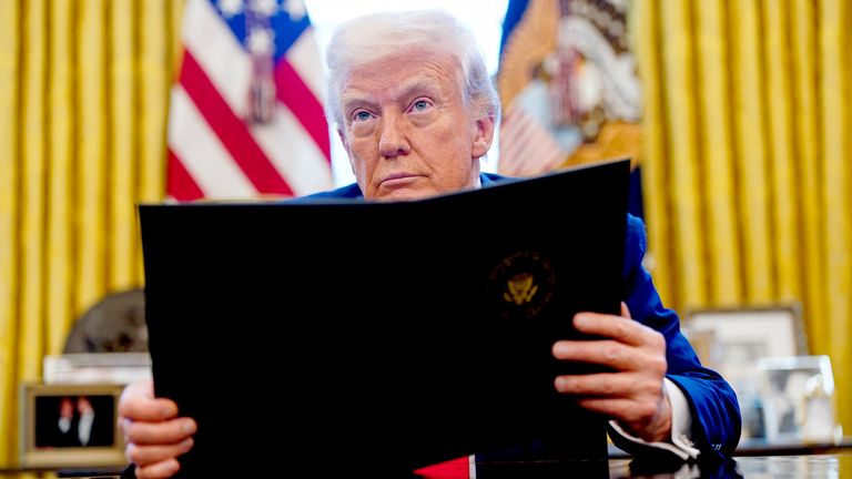 Donald Trump looks on, as he signs executive orders and proclamations in the Oval Office at the White House in Washington.
Pic: Reuters