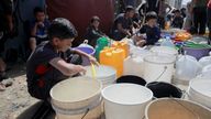 Palestinian children fill water containers at a tent camp, in Gaza.
Pic: Reuters