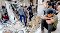 A man sits as Palestinians gather at the site of an Israeli strike on a house in Jabalia, in the northern Gaza Strip May 23, 2025. REUTERS/Mahmoud Issa
