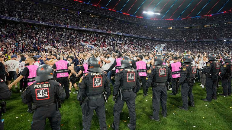 Police try to contain PSG fans on the field at Allianz Arena in Munich. Pic: AP