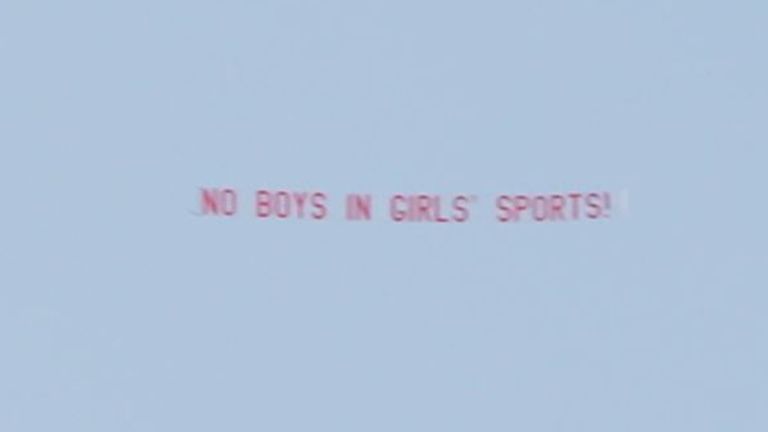 A plane, paid for by women's advocacy groups, flies a banner over the stadium that reads: 'no boys in girls sports'