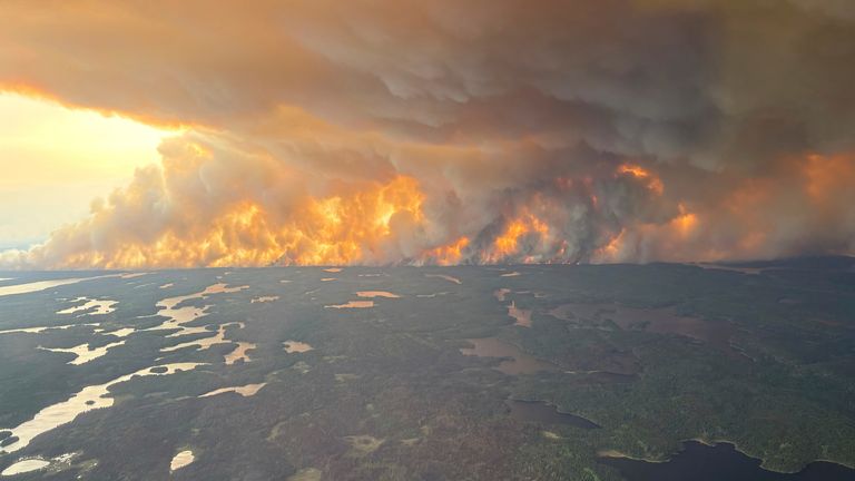 Flames and dark clouds of smoke are billowing into the sky in Flin Flon, Manitoba. Pic: AP