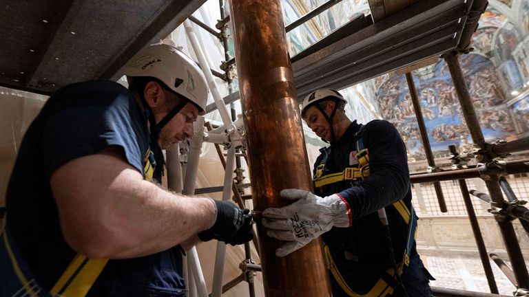 Workers installing a chimney pipe in the Sistine Chapel. Pic: Vatican Media/Reuters