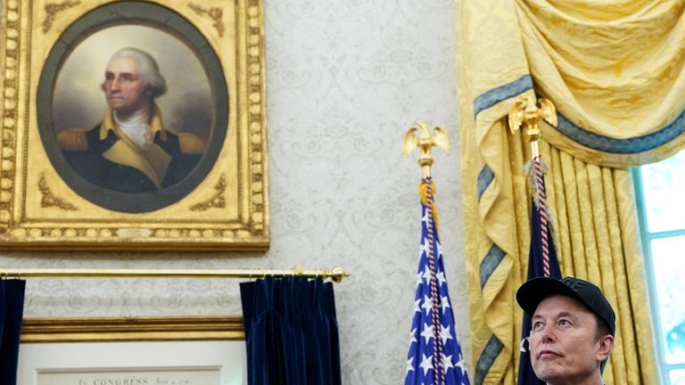 Elon Musk stands in the Oval Office - with more gold decor brought in by Donald Trump - 30/05/25. Pic: Reuters