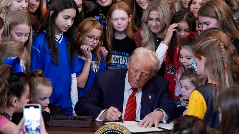FILE - President Donald Trump signs an executive order barring transgender female athletes from competing in women's or girls' sporting events, in the East Room of the White House, Feb. 5, 2025, in Washington. (AP Photo/Alex Brandon, file)
