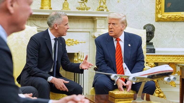 Arkasında Trump'ın bazı kupaları ve Oval Ofis'te Kanadalı Mark Carney. Resim: AP