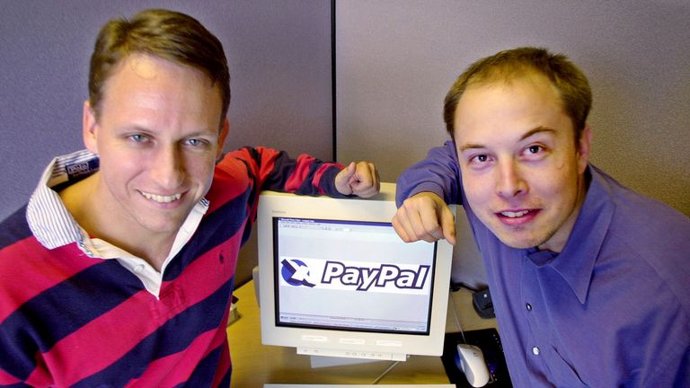 FILE - PayPal Chief Executive Officer Peter Thiel, left, and founder Elon Musk, right, pose with the PayPal logo at corporate headquarters in Palo Alto, Calif., Oct. 20, 2000. Musk may want to send “tweet” back to the birds, but the ubiquitous term for posting on the site he now calls X is here to stay, at least for now. For one, the word is still plastered all over the website formerly known as Twitter. Write a post, you still need to press a blue button that says “tweet” to publish it. To repo