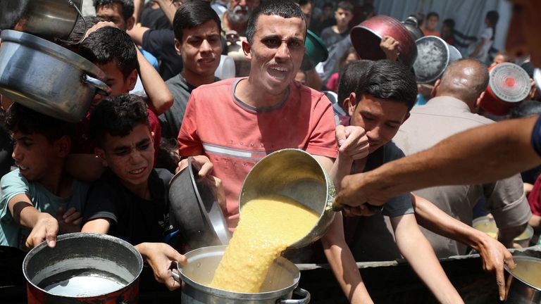 Palestinians waiting for food provided by a charity kitchen, in Jabalia, Northern Gaza Strip, May 19, 2025. REUTERS/Mahmoud Issa