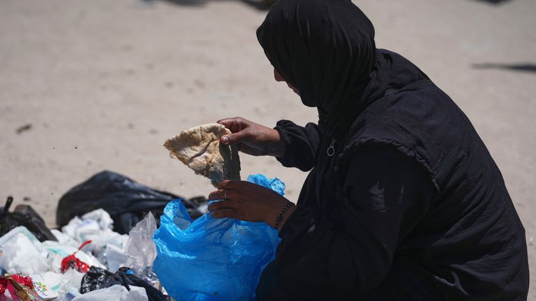 Islam Abu Taeima finds a piece of bread in a pile of rubbish in Gaza City. Pic: AP.