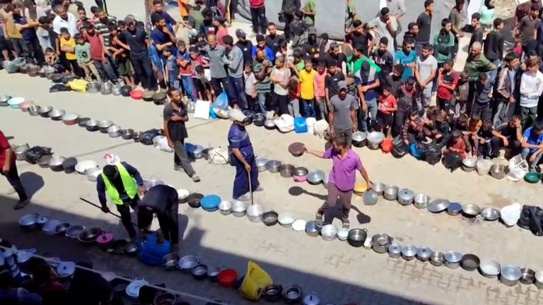 People in West Gaza line up to receive food after Israel said it lifted an 11-week blockade and allowed around 300 aid trucks through.

