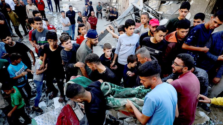 Palestinians carry a body at the site of an Israeli strike on a house, in Jabalia, northern Gaza .
Pic: Reuters