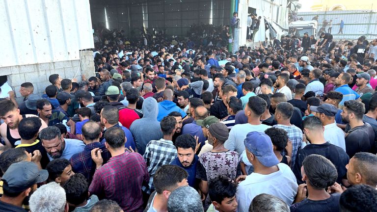Palestinians gather at an aid distribution centre. Pic: Reuters