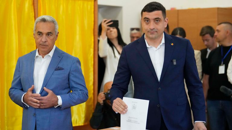 Presidential candidate George Simion (right) casts his vote next to Calin Georgescu.
Pic: AP/Vadim Ghirda