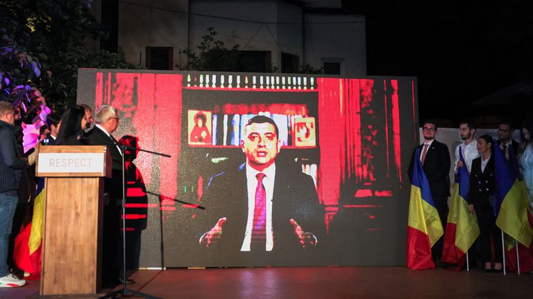 Supporters watch George Simion speak followig the exit poll results.
Pic: Reuters/Louisa Gouliamaki