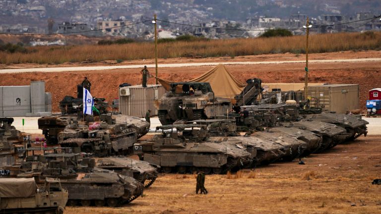 Israeli soldiers work on tanks at a staging area near the Gaza border. Pic: AP