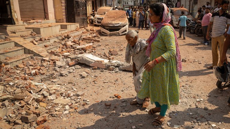 Women walk towards their damaged house, following Pakistan's military operation against India, in Rehari, Jammu, May 10, 2025. REUTERS/Adnan Abidi