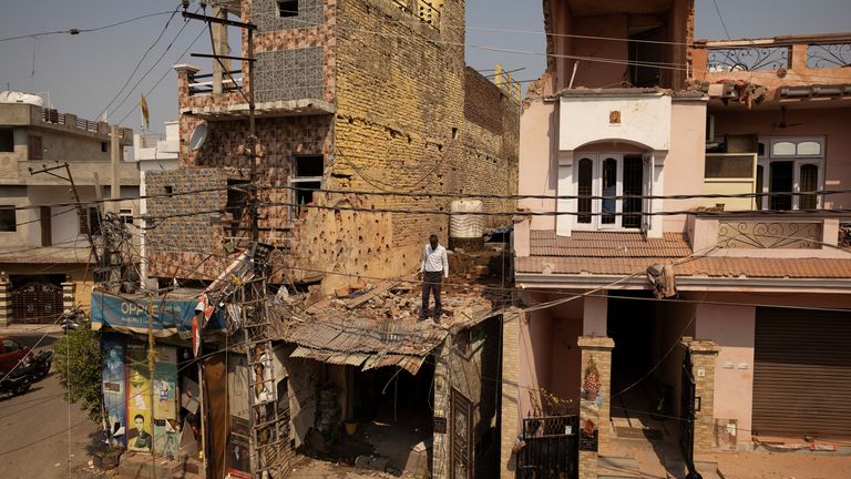 10 mai 2025, Jammu, Reuters / Adnan Abidi, un homme se tient parmi les fragments de toit de la maison endommagée après l'opération militaire du Pakistan contre l'Inde.