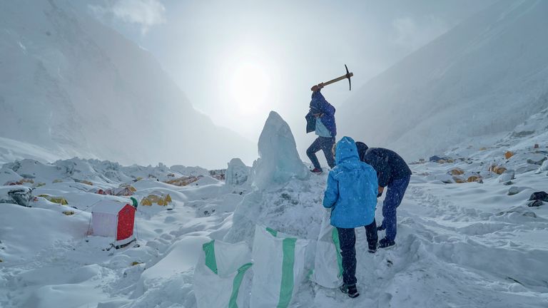 A member of the kitchen crew of an expedition to the summit of Mount Everest collects ice for drinking water at Camp 1, Nepal, May 2, 2025. (AP Photo/Pasang Rinzee Sherpa)