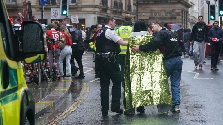 Una persona envuelta en una manta de emergencia está siendo llevada desde la escena. Pic: PA