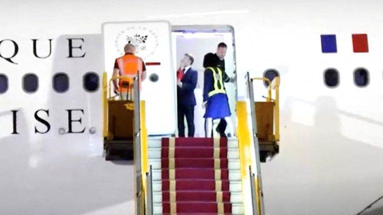 Fransa Cumhurbaşkanı Emmanuel Macron, bir el ortaya çıkıp 25 Mayıs 2025'te Hanoi, Vietnam'da bir videodan bu ekrangrabada bir uçağın kapısının yakınında duruyor. Reuters TV/Via Reuters