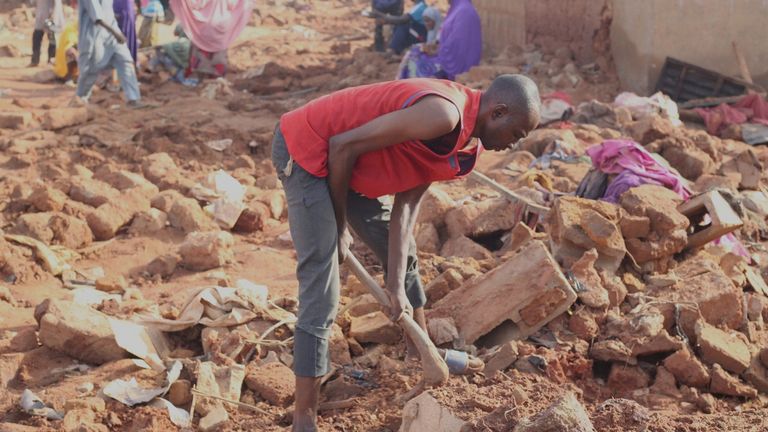 A man searches the rubble in a flooded area after heavy rainfall in the market town of Mokwa, north-central Nigeria, Saturday May 31, 2025. (AP Photo/Usman Salihu Mokwa)