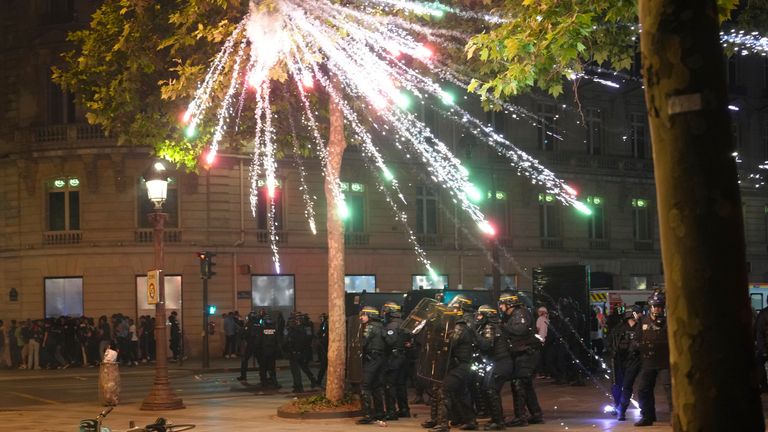 Fireworks explode over police in Paris after PSG win the Champions League. Pic: AP