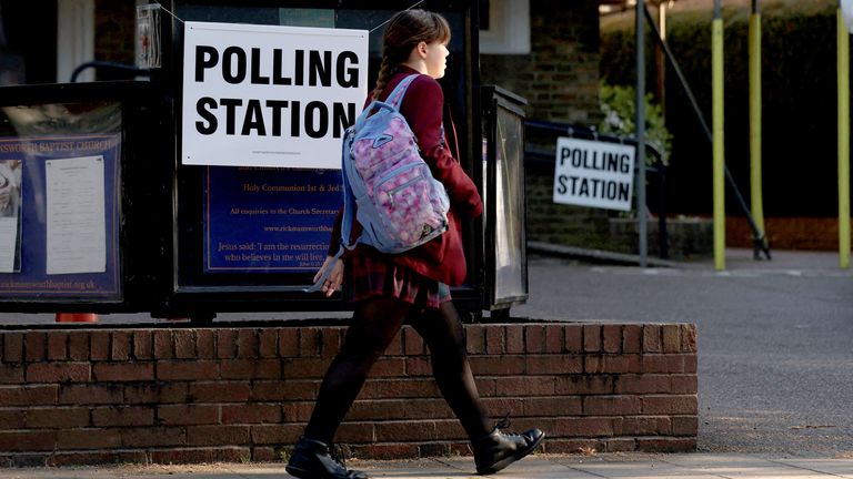 A pupil  walks past   a polling presumption    successful  Rickmansworth, Britain, May 1, 2025. REUTERS/Suzanne Plunkett