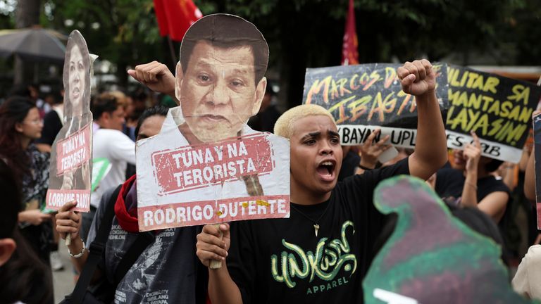 A man holds a sign against former Philippine President Rodrigo Duterte during a protest in Manila, Philippines on Friday. March 28, 2025. (AP Photo/Basilio Sepe)  