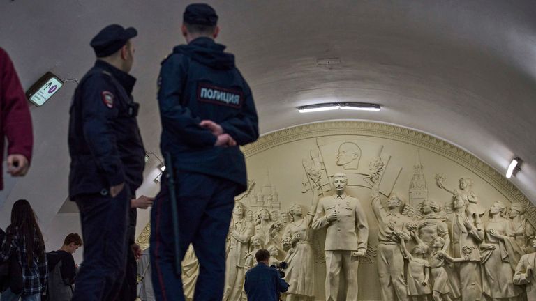Police officers stand in front of the statue showing the former Soviet Union leader.
Pic: AP/Alexander Zemlianichenko