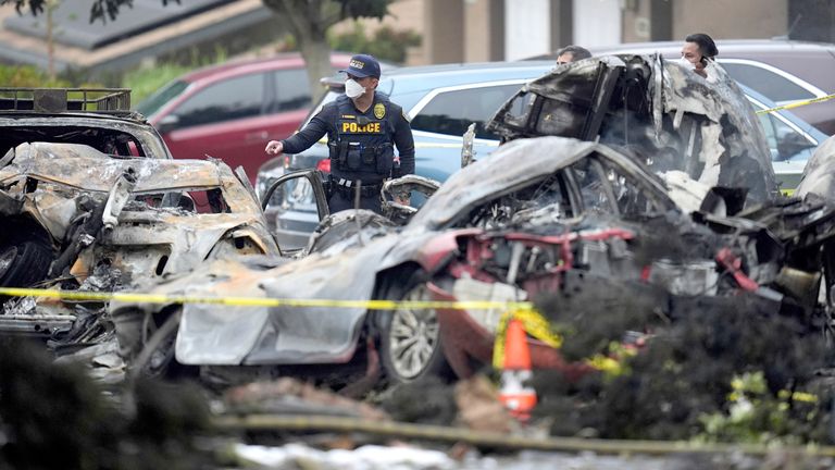 Authorities work the scene where a small plane crashed into a San Diego neighborhood, setting several homes on fire and forcing evacuations along several blocks early Thursday, May 22, 2025. (AP Photo/Gregory Bull)