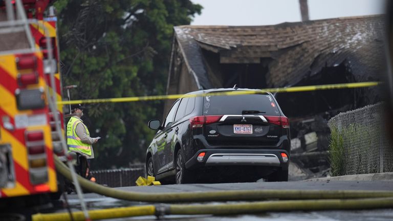 Authorities work the scene where a small plane crashed into a San Diego neighborhood, setting several homes on fire and forcing evacuations along several blocks early Thursday, May 22, 2025. (AP Photo/Gregory Bull)