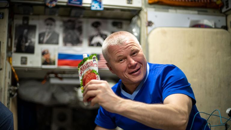 Roscosmos cosmonaut Oleg Novitskiy shows off a drink bag during a midday meal aboard the International Space Station in 2021. File pic: NASA