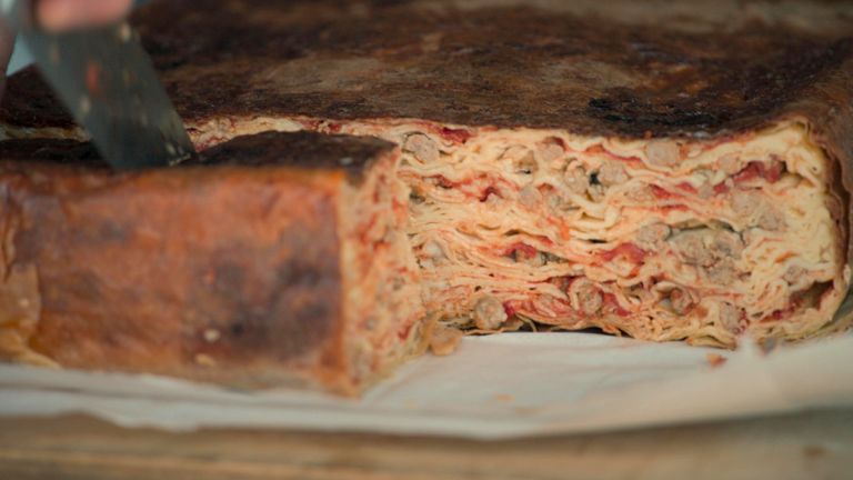 Timballo being cut, revealing the intricate layers of crespelle and meatballs inside. Pic: National Geographic