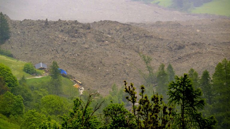 Yıkılan binalardan gelen enkazlar köyde görülebilir. Pic: AP