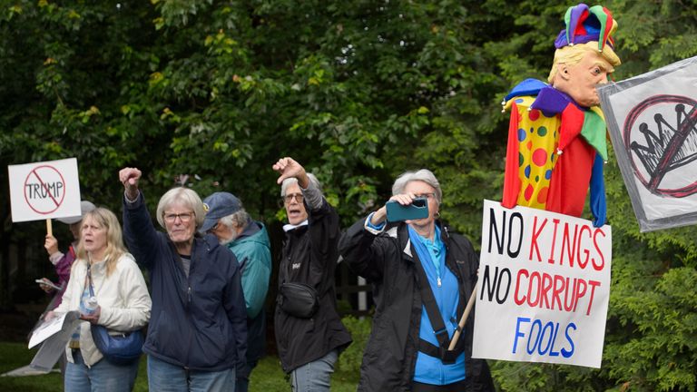 Demonstrators protest near Trump National Golf Club before the arrival of the president. 
Pic: AP/Rod Lamkey Jr