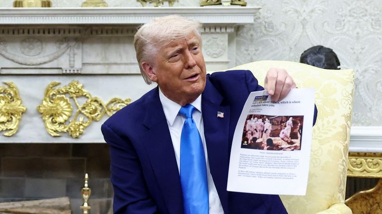 Başkan Trump bir blogun basılı bir kopyasını tutuyor. Blogdaki görüntü DRC'deki yardım çalışanlarını gösteriyor. Kredi: Reuters