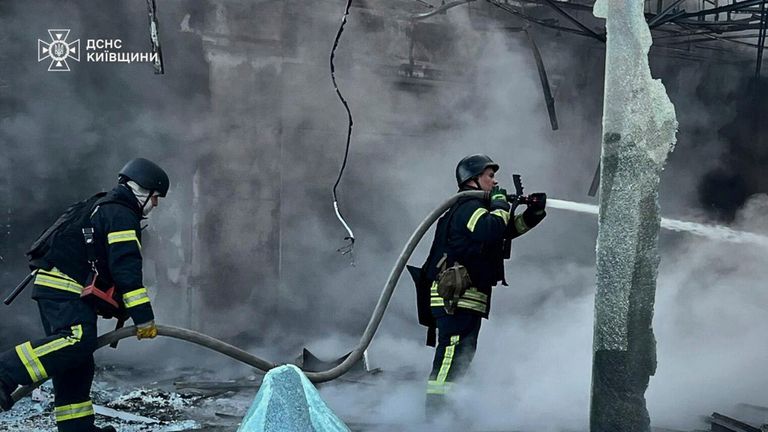 The Ukrainian Emergency Service work to put out flames after drone strikes in Kyiv. Pic: AP