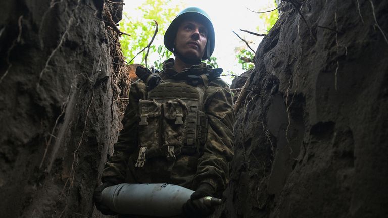A serviceman of the 141st Separate Mechanized Brigade of the Ukrainian Armed Forces carries an artillery shell before firing towards Russian troops, at a position in a front line, amid Russia's attack on Ukraine, in Donetsk region, Ukraine May 13, 2025. REUTERS/Stringer