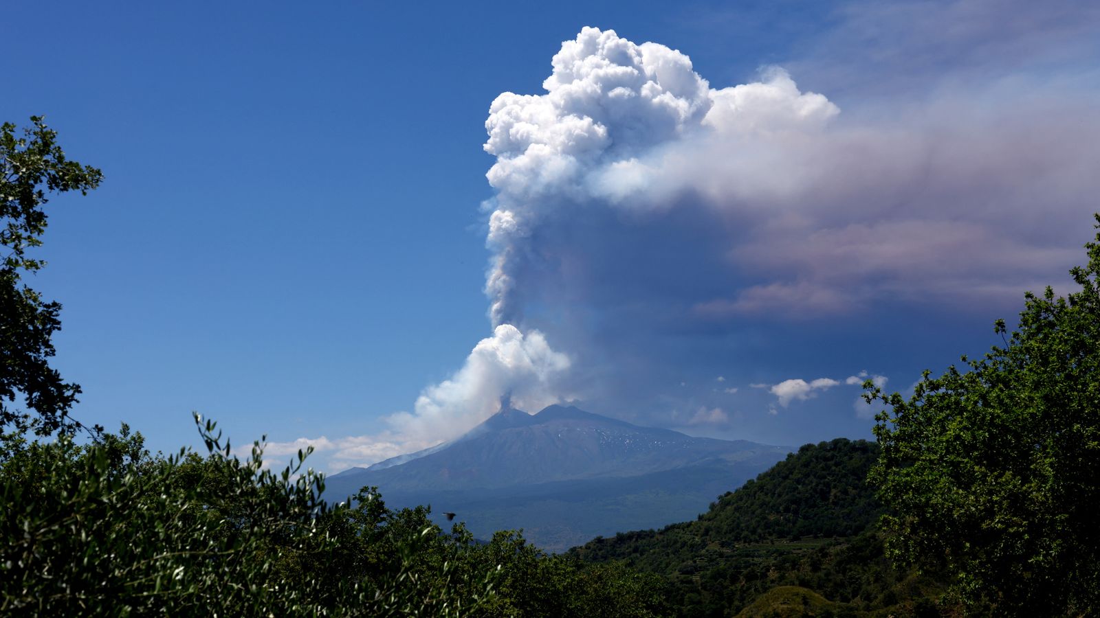 Mount Etna erupts in Sicily, sending huge plume of ash into sky and tourists fleeing