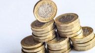 Macro close-up of one pound coins on a white background.

