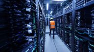 An employee walks between computers in Germany's Jupiter supercomputer. File pic: AP