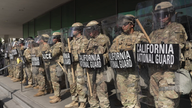 California National Guard deployed outside a Los Angeles city building, facing anti-ICE protesters out of frame