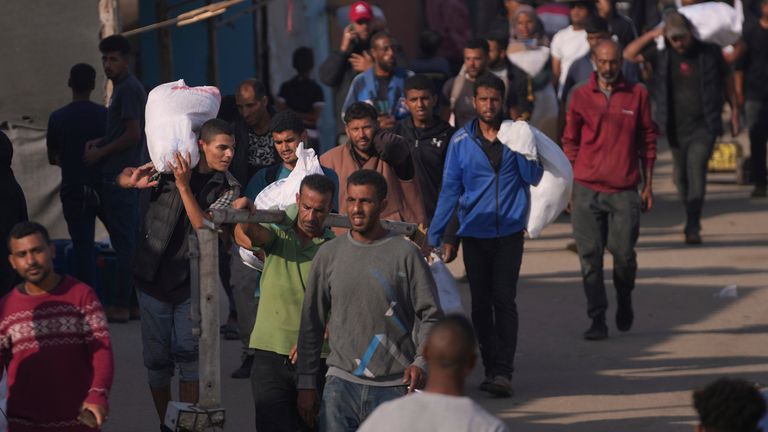 Palestinians carry bags containing food and humanitarian aid packages delivered by the Gaza Humanitarian Foundation, a U.S.-backed organization approved by Israel, in Khan Younis, southern Gaza Strip, Sunday, June 1, 2025. (AP Photo/Abdel Kareem Hana)