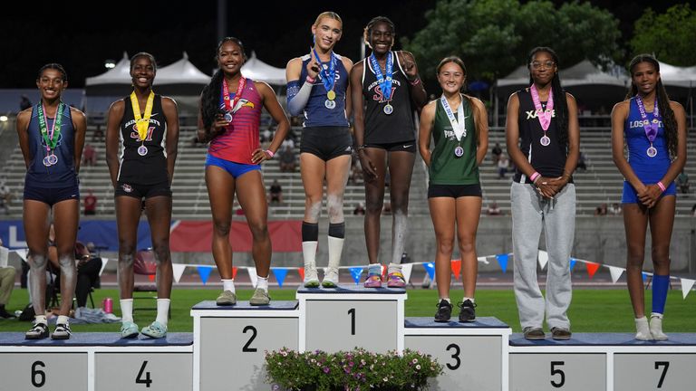 AB Hernandez shares the first-place spot on the podium with Kira Gant Hatcher during the triple jump medal ceremony. Pic: AP