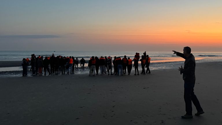 Alex Rossi points to migrants in Dunkirk, France, preparing to cross the English Channel
