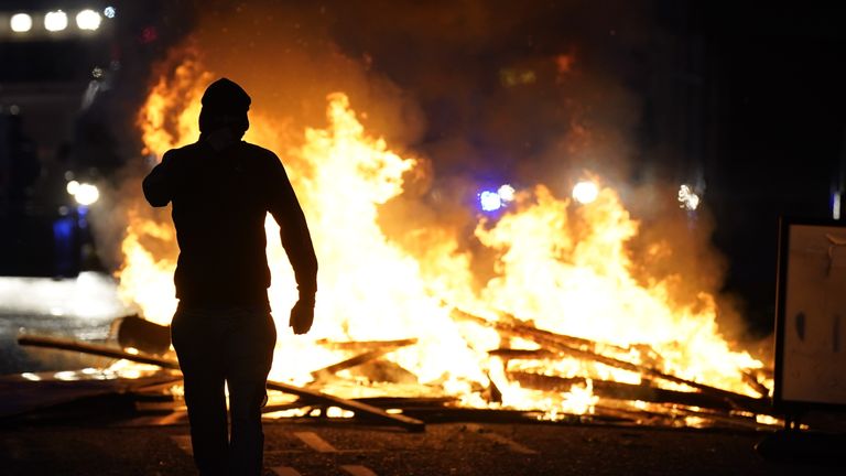 A person stands in front of a fire in a Ballymena street. Pic: PA
