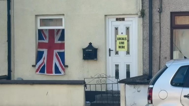 A sign on a door in Ballymena reading, 'locals live here' 