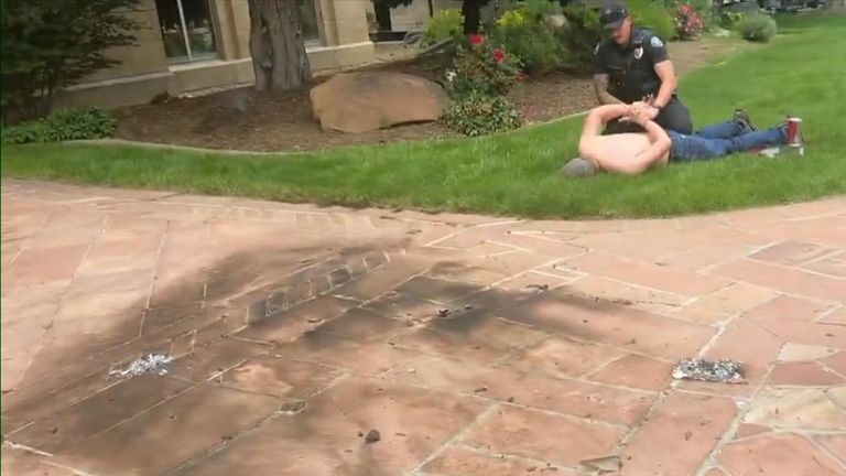 Topless man being pinned down by police
