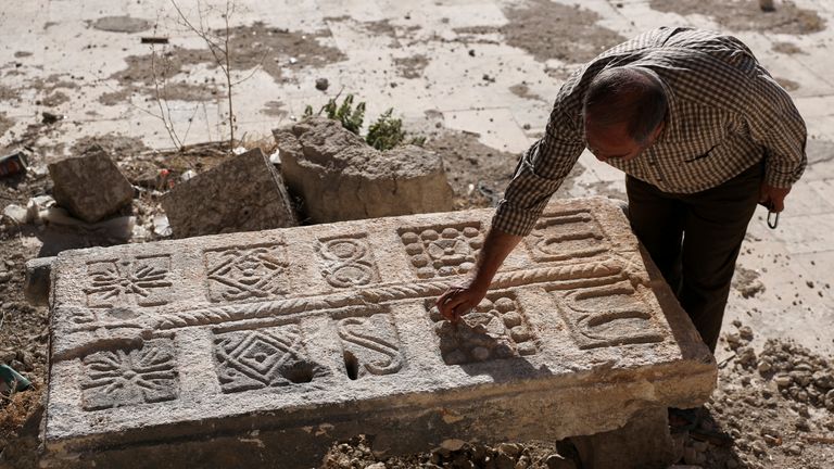 A guard inspects an engraved stone found at a Byzantine underground tomb complex in Maarat al-Numan, Syria. Pic: AP
